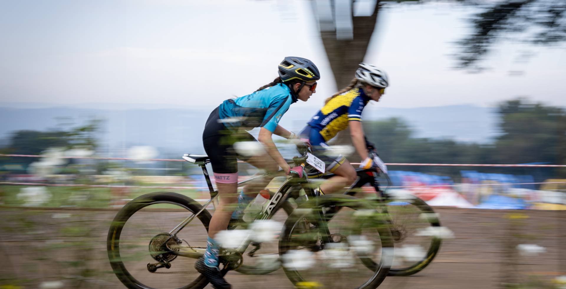 Two riders racing past the race village